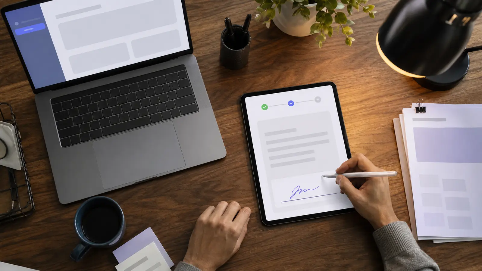 Hand signing a PDF contract on a tablet with stylus